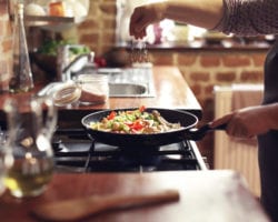 woman cooking in frying pan