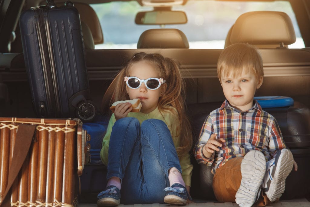 kids sitting in back seat on holiday road trip