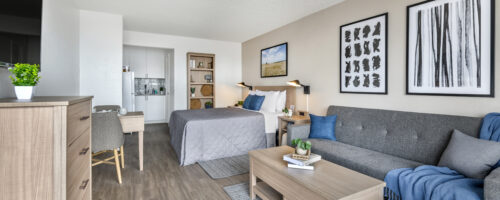 Extended stay suite with in-room kitchen, dining area, and sleeper sofa with coffee table.