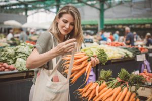 a lady buying carrots at the dallas farmers market