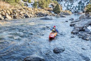 A man kayaking on the river, a fun outdoor activity in Denver. 