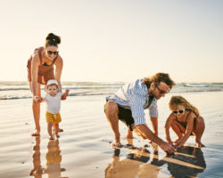A family enjoying their vacation on the beach while staying at an InTown Suites property.