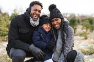 a small family posing for a picture during a winter vacation