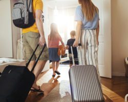 A family walking into an InTown suite, an affordable temporary housing option.