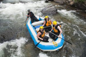 A group enjoying a Denver outdoor activity, whitewater rafting on the river. 