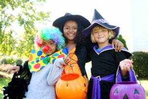 Three kids dressed in Halloween costumes at a fall festival in Houston. 