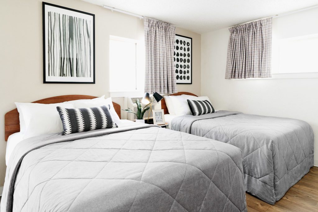Partially renovated suite with new bedding and storage bed frame.