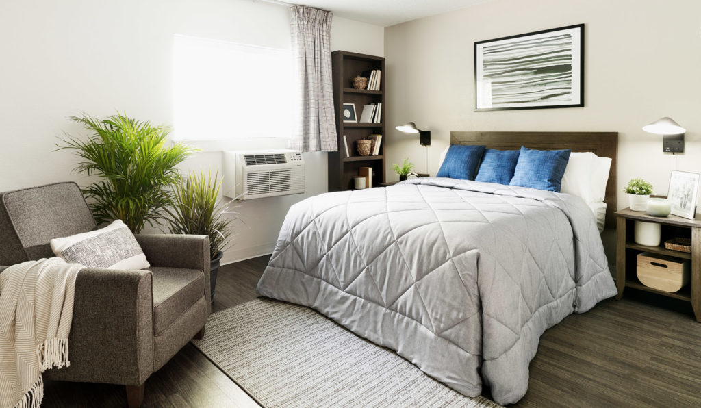 Fully renovated premium suite with new recliner chair, bookcase, and bed with storage bed frame.